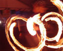 fire artist performing a staff twirling dance routine