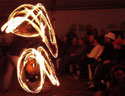 fire performer entertains with staff spinning duet