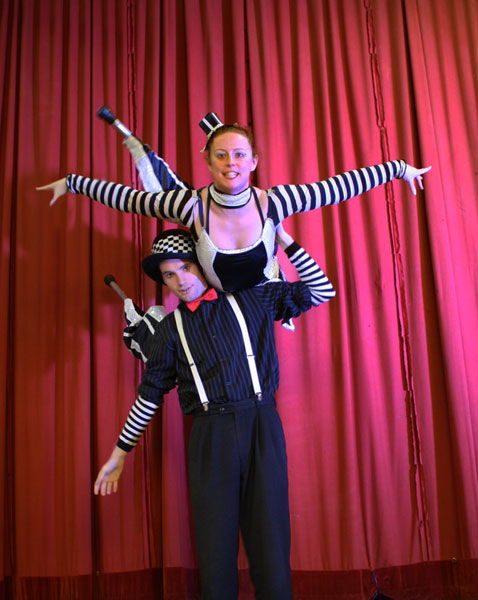 stilt walkers performing next to the red curtain in newcastle, australia, stilt acrobatics, circus, eve everard and luke forrester