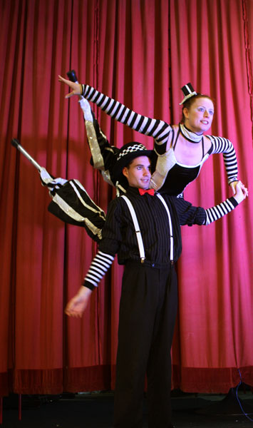 stilt walkers performing next to the red curtain in newcastle, australia, stilt acrobatics, circus, eve everard and luke forrester