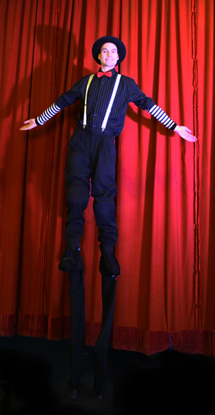stilt walkers performing next to the red curtain in newcastle, australia, stilt acrobatics, circus performer